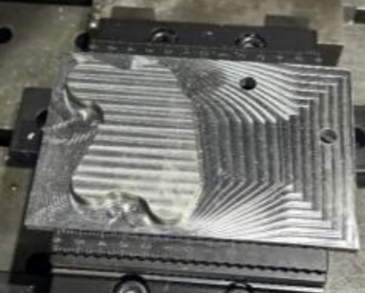 Real milled part — surface finish and pocket geometry visible after the first machining phase